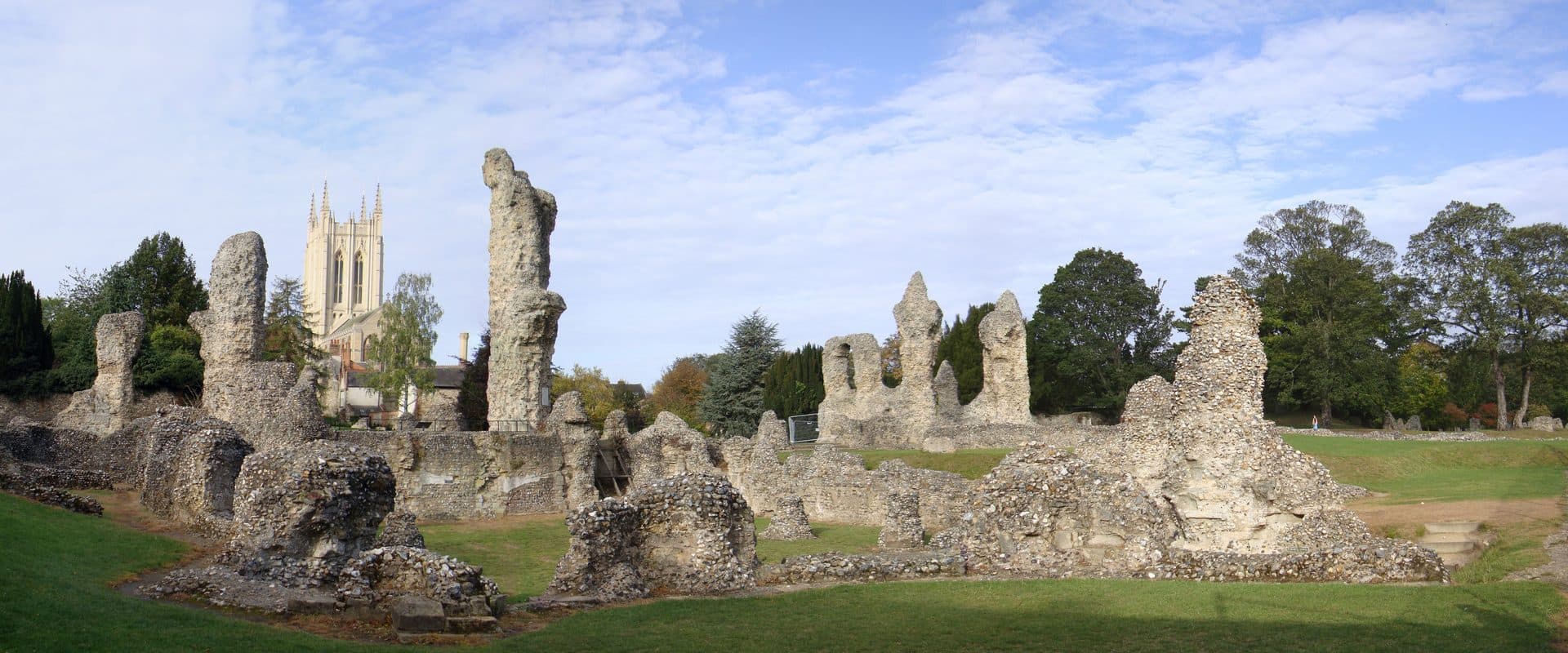 Panoramic ruins of Bury St Edmunds Abbey with the tower of St James' Cathedral rising behind the crumbling stonework