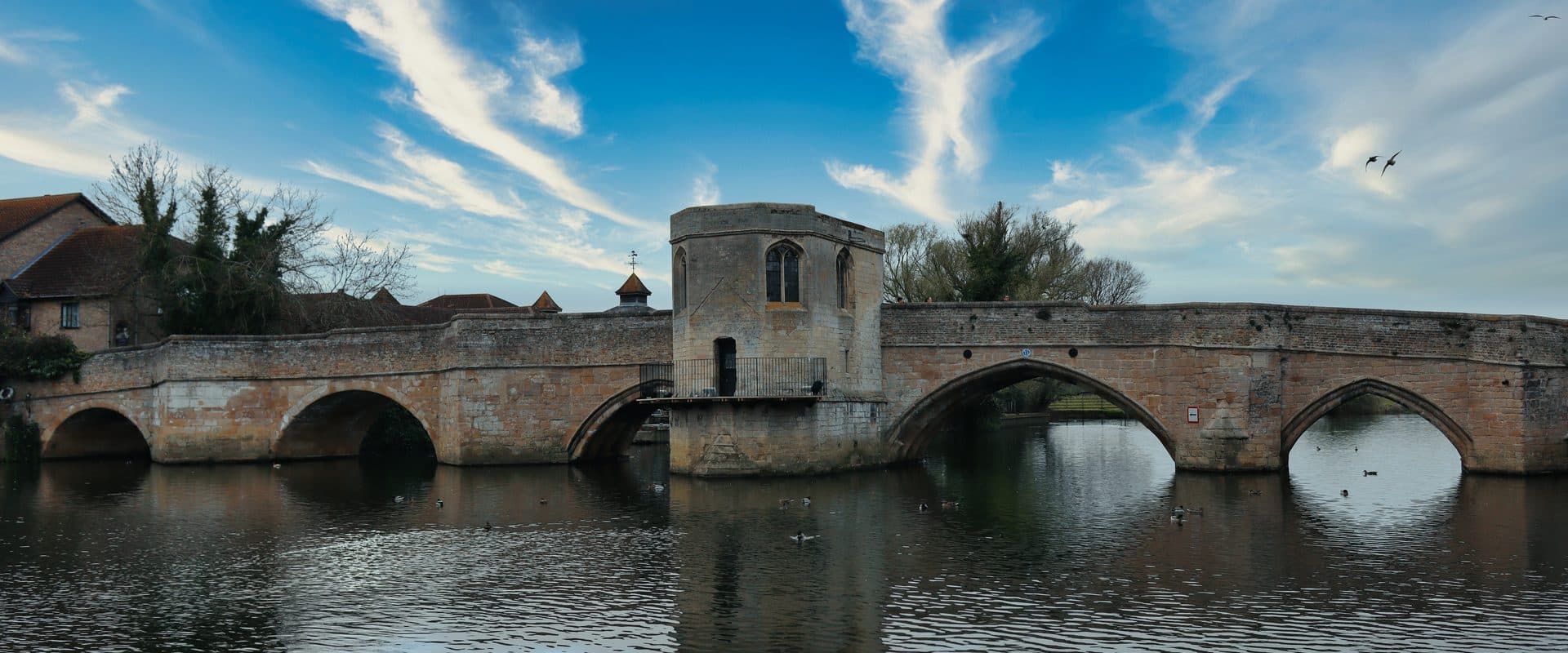 The medieval stone arches of St Ives Bridge, Cambridgeshire, spanning the River Great Ouse with its rare chapel built into the second pier